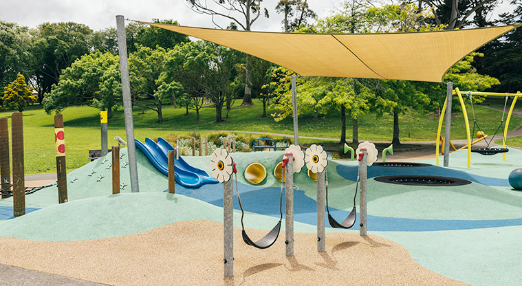 Marlborough Park - Low sling swings with interactive flowers on the poles, and the rest of the junior play area in the background. Photo credit: J Farnworth.