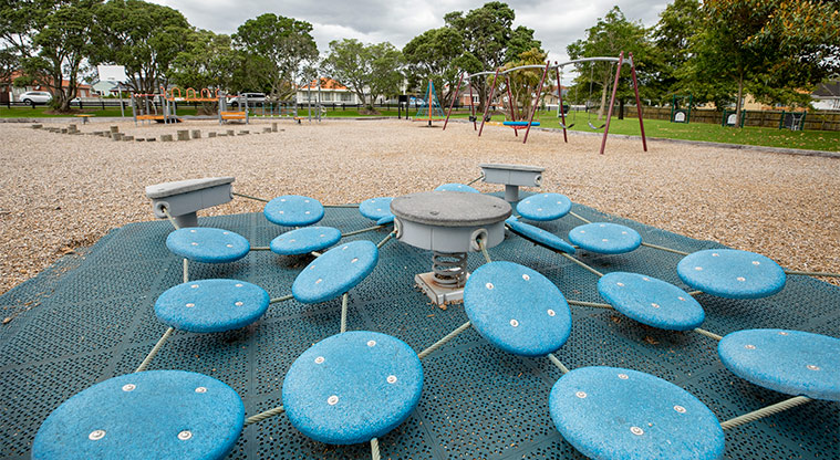 May Road War Memorial Park - Blue balance pads with the rest of the playground in the background.