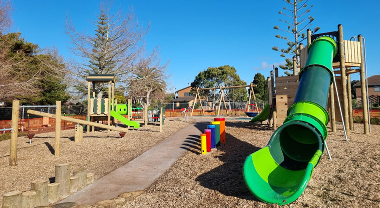Maygrove Park – Playground with a large green slide, swings, seesaw, junior play module, and more.