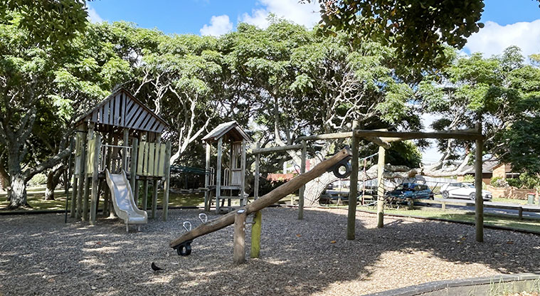 Melville Park - Seesaw with the rest of the wooden playground under the trees in the background. Photo credit: S Hulse.