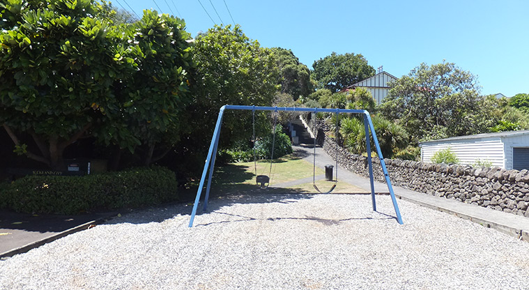 Monkey Hill - Set of two swings with the path leading up the rise on the rights, and trees on the left and in the background. Photo credit: J Grigg.