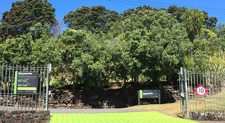 Maungauika / North Head - Gates at the main entrance with signs and trees in the background.