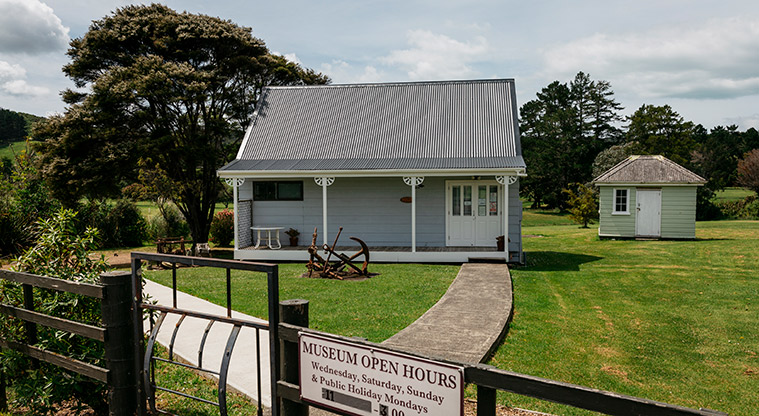Onetangi Sports Park - Waiheke Museum and historical village buildings with a path, open grassed areas and trees.