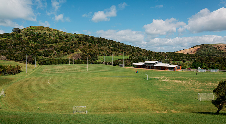 Onetangi Sports Park - Sports fields with the pavilion and bush in the background.