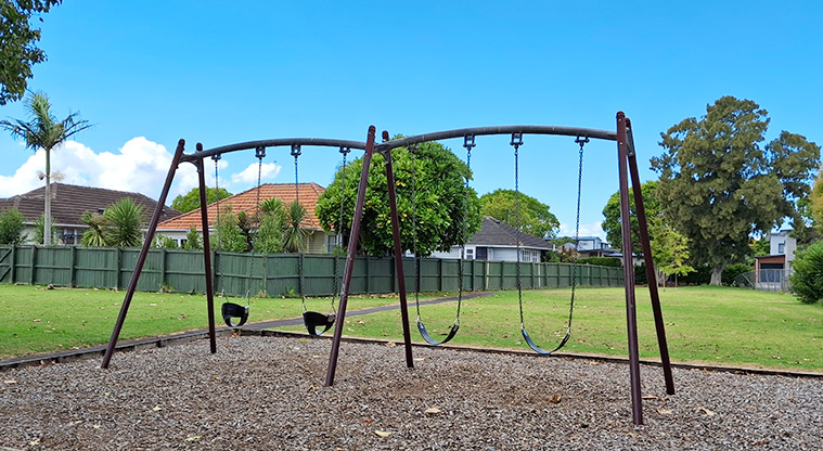Orchard Reserve - Swing set with open grassed space and trees in the background. Photo credit: T Hodder.