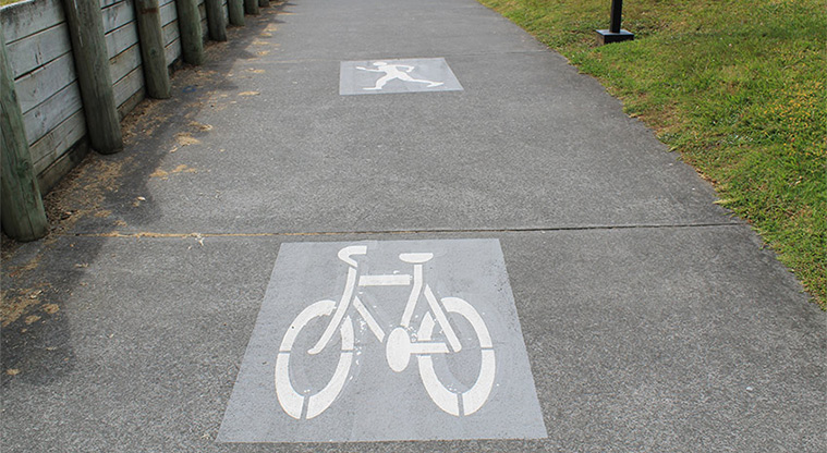 Pōhutukawa Reserve - Section of the Te Ara Tahuna / Ōrewa Estuary Path with a bike and person painted on it showing it as a shared path.. Photo credit: M Loubser.