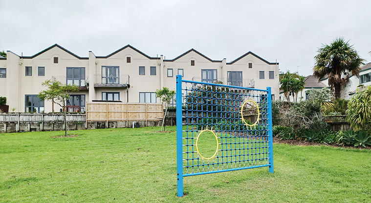 Ponderosa Reserve - Soccer goal wall with open grassed space and residential housing in the background.
