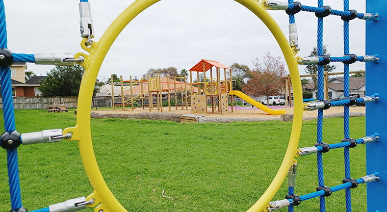Ponderosa Reserve - Looking through one of the holes in the soccer goal wall to the playground in the background.