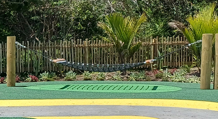 Rānui Domain - One of the hammocks with a section of the garden and fence in the background.