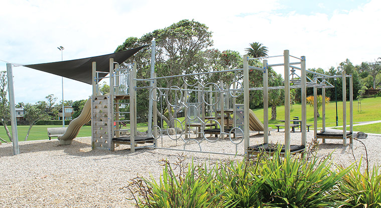 Red Beach Park - Playground with swings, climbing equipment, spinning toys, seating, and shade cloth covering part of the area. Photo credit: M Loubser.