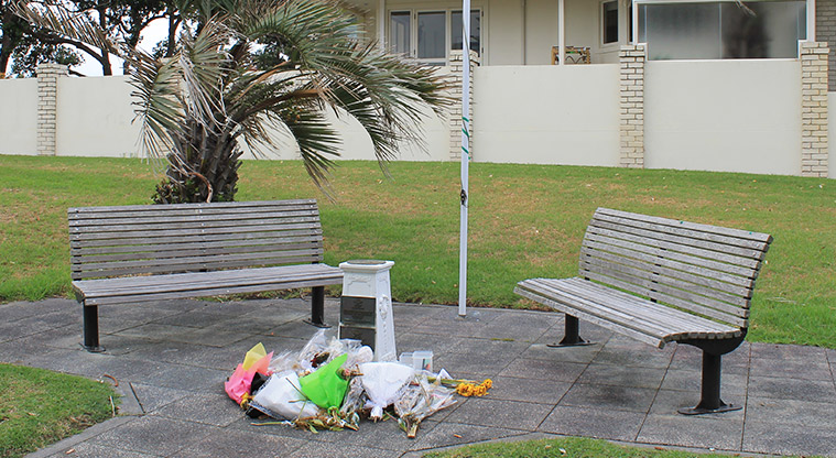 Remembrance Reserve - Floral memorials on the ground in front of a monument and two parks benches. Photo credit: M Loubser.