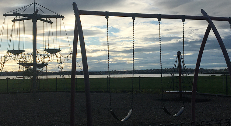 Roberta Reserve - Climbing nets and swings with a view of the Tāmaki Estuary at dusk.