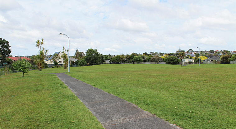 Rosario Reserve - Open grassed area with trees in the background, a street light and a path. Photo credit: M Loubser.