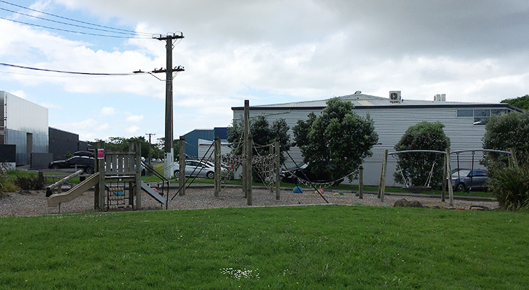 Sainsbury Reserve - Open grassed area with the playground and buildings in the background. Photo credit: S Hulse.