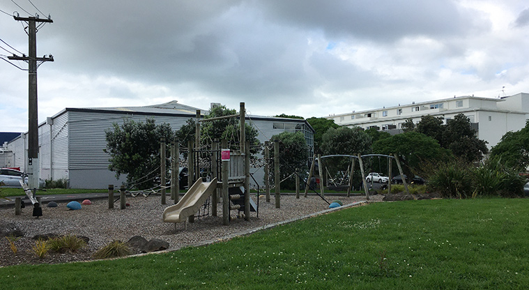 Sainsbury Reserve - Open grassed area with the playground and trees in the background. Photo credit: S Hulse.