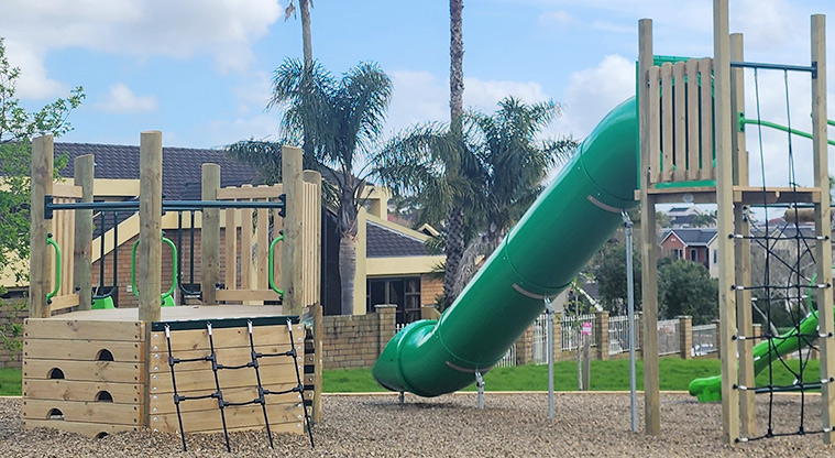 Santa Cruz Park - Junior play module with a climbing wall and net leading up to a low platform, with the high enclosed slide on the right.