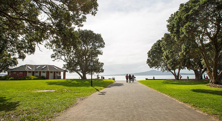 Selwyn Reserve - Path through the middle of the reserve with the changing rooms on the left and views out to Rangitoto Island.