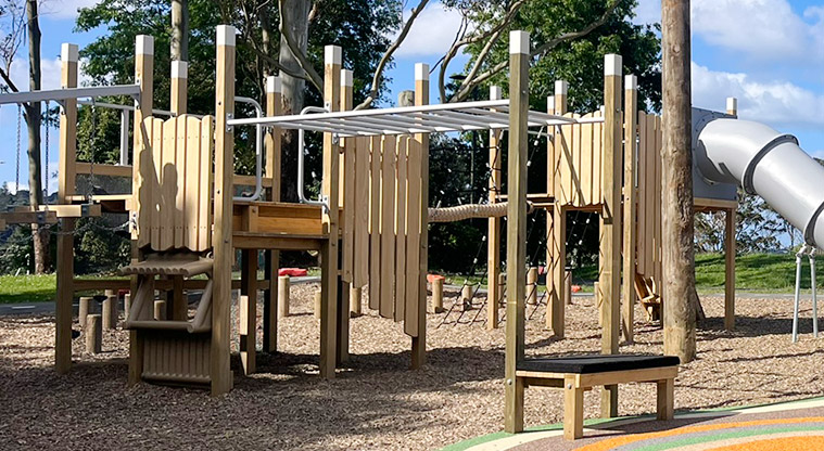 Shepherds Park - Wooden play structure with climbing equipment, ramps and a large slide.