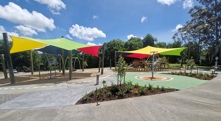 Shepherds Park - Section of garden with the playground under brightly coloured shade sails in the background.