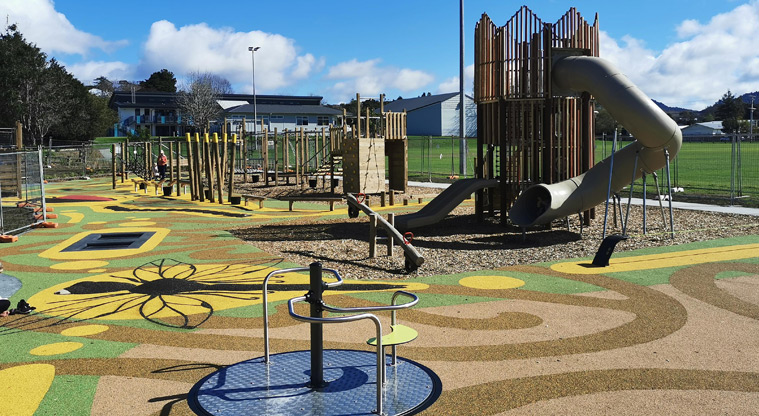 Shoesmith Domain Recreation Reserve - Large cheerful playground with a carousel and mostly wooden playground equipment in the background. Photo credit: Kara Burn.