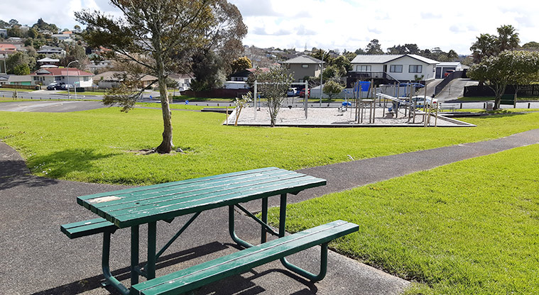 Te Kakau - Picnic table and paths with the playground in the background.