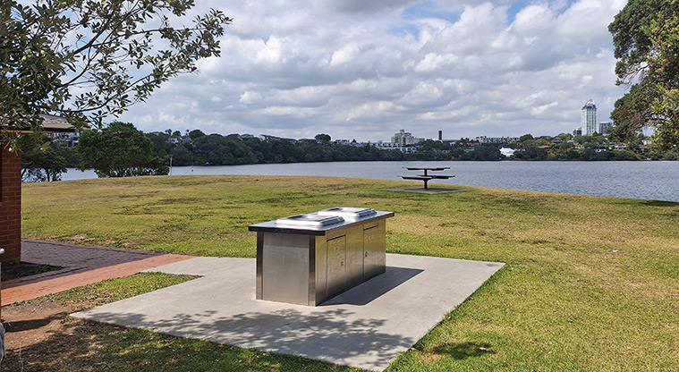 Sylvan Park - The electric barbecue with a picnic table and view over the lake in the background.