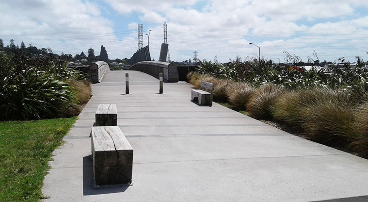 Taumanu Reserve - Path showing seating with Taumanu Bridge in the background. Cross over the bridge to get to Onehunga Bay Reserve.