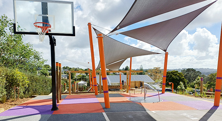 Taurus Crescent Reserve - Basketball hoop, large shade sails covering parts of the playground, and the rest of the playground in the background.