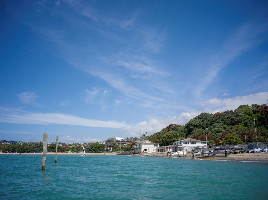 Two mooring posts in the sea in front of a long boat ramp.