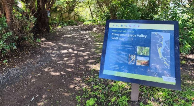 The Sandspit - Walkway with trees on both sides and sign board.