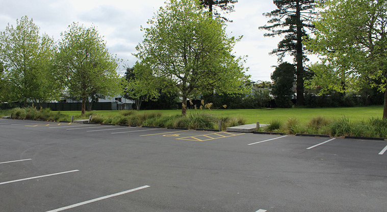 Tūī Glen Reserve - Section of one of the car parking areas with a mobility park, and open space and trees in the background.