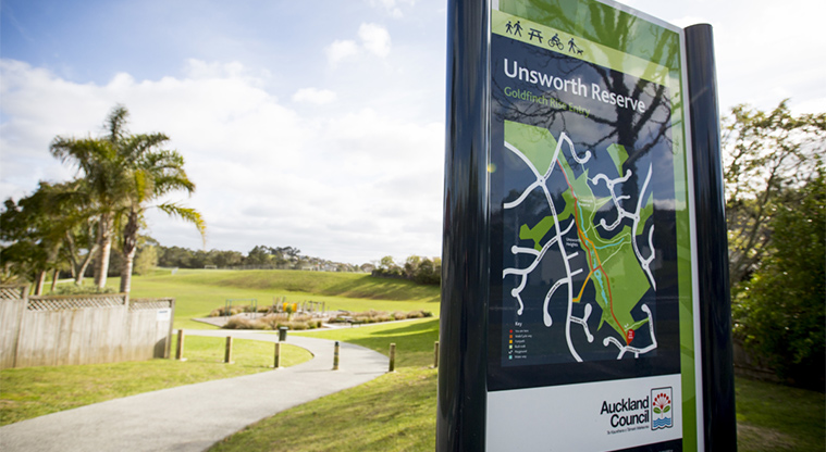 Unsworth Reserve - Entrance sign with the reserve and playground in the background. Photo credit: Jay Farnworth.