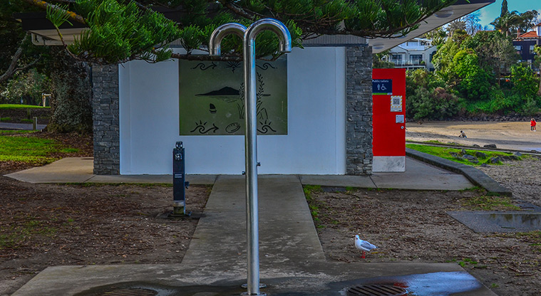 Waiake Beach Reserve - Outdoor shower with the toilet block in the background. Photo credit: Aleksandar Ćirilović.