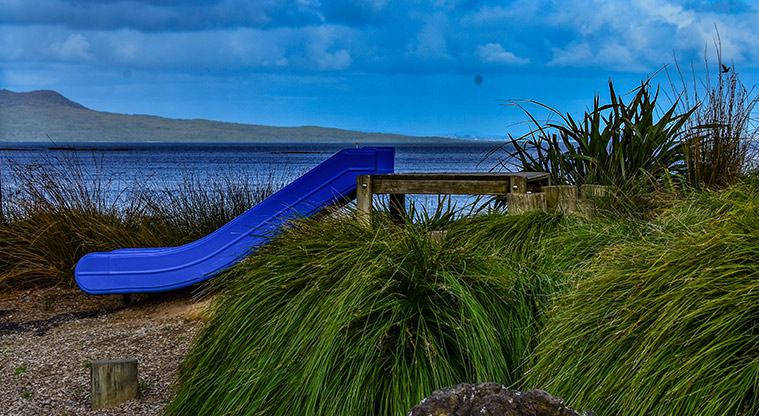 Waiake Beach Reserve - Blue slide with a view of the sea and island in the background. Photo credit: Aleksandar Ćirilović.