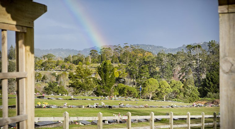 Waikumete Cemetery – Looking out over one of the sections of the cemetery, with the Waitakere Ranges and a rainbow in the distance.