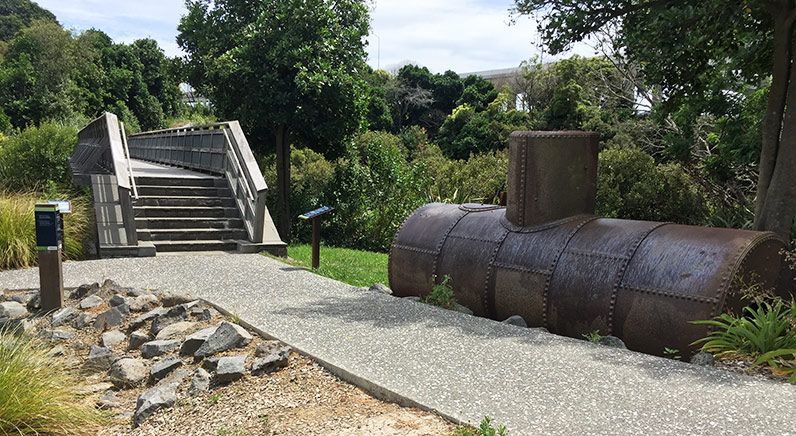 Waterview Reserve – The old tannery boiler in the heritage section of the reserve, with steps and a bridge over Te Auaunga (Oakley Creek).