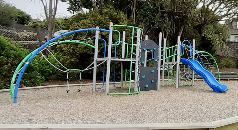 Wharua Reserve - Play structure with ladders, rope nets, climbing wall, and a slide.