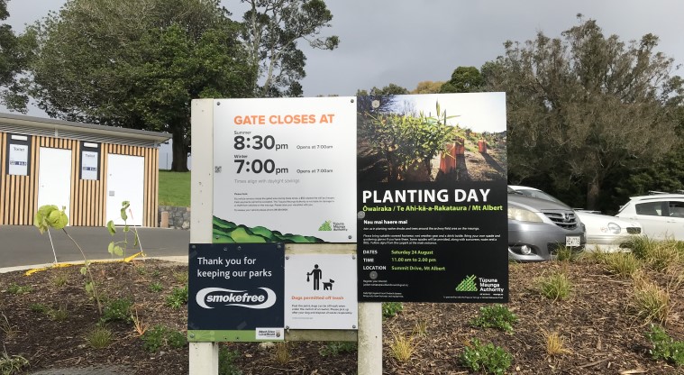 Ōwairaka / Te Ahi-kā-a-Rakataura / Mt Albert Path - Sign showing the opening and closing hours of the park, and details of a planting day.