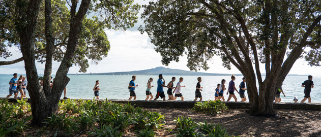 Group of runners with Rangitoto in the background.