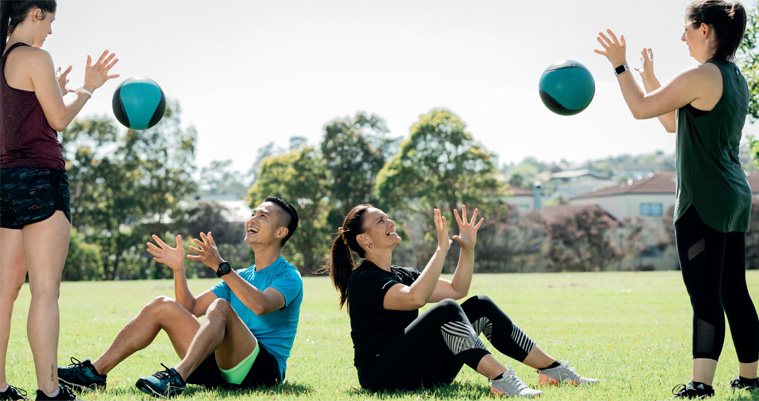 Four people building their fitness in a park.