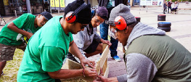 Photograph of four young men fixing a fence as part of fix it event in South Auckland