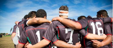 Group of rugby players huddled together.