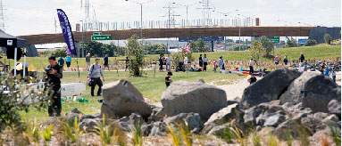  Photograph of the Onehunga foreshore restoration project, there are people milling around the foreshore and boats on the shore.