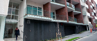 Photograph of new housing development from the street looking up at the first three levels of the apartment block.