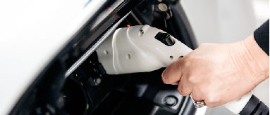 Person charging an electric vehicle.