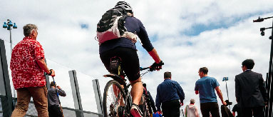 Person riding a bike and other people walking across a bridge.