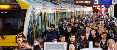 Crowd of people next to a train at Britomart Train Station.