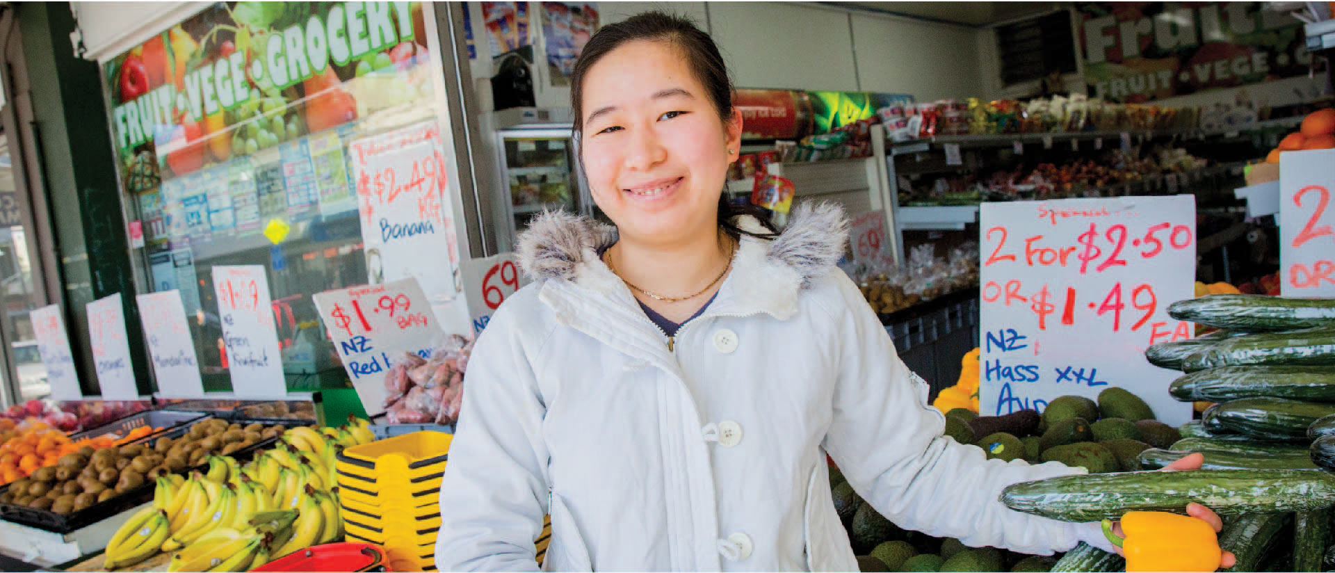 A person standing outside a fruits and vegetables store.