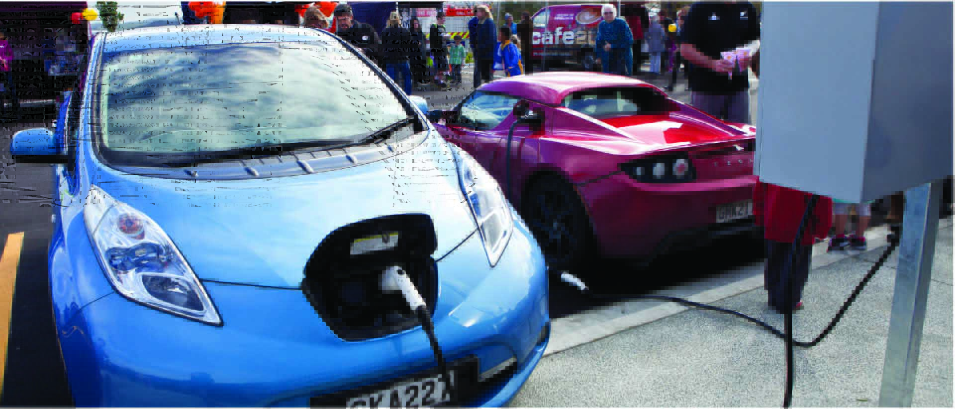 Two electric vehicles sharing a charging station.