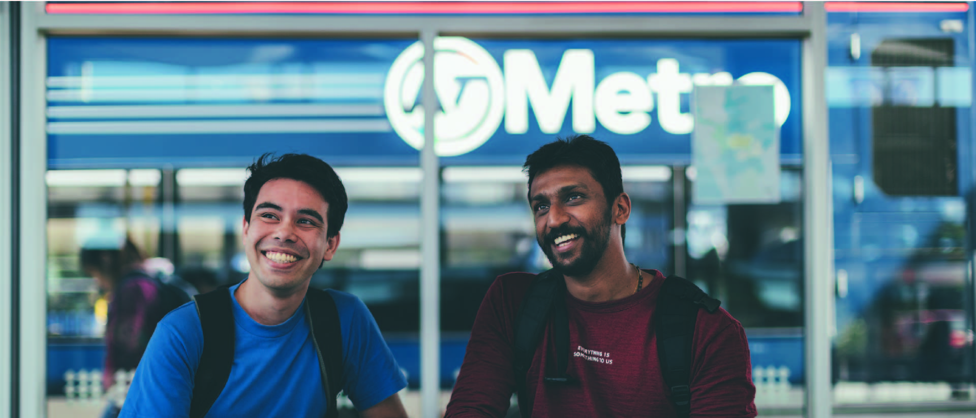 Two students at a public transport station.